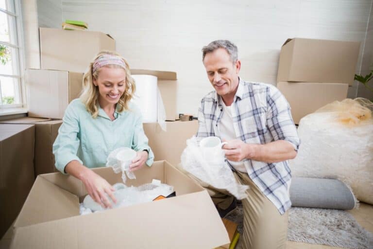 Smiling Couple While Packing Mugs