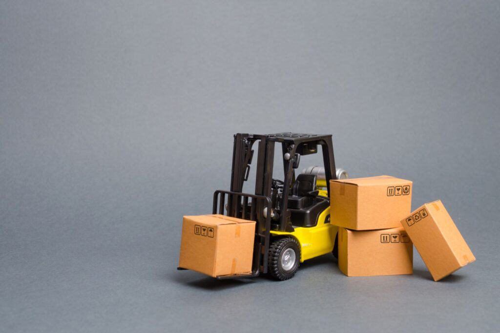 A yellow forklift toy truck with cardboard boxes for moving