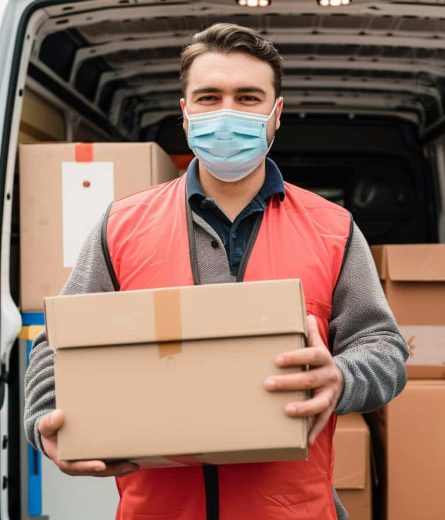 www.manwithavan-croydon.co.uk - a man wearing a face mask holding a brown box